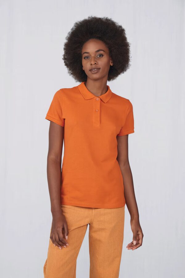 olo femme B&C CGPW440. 100 % coton biologique piqué, 170 g/m², col et manches en côte 1×1, 2 boutons ton‑sur‑ton, tag‑free. Parfait pour broderie, flocage ou impression pro. orange