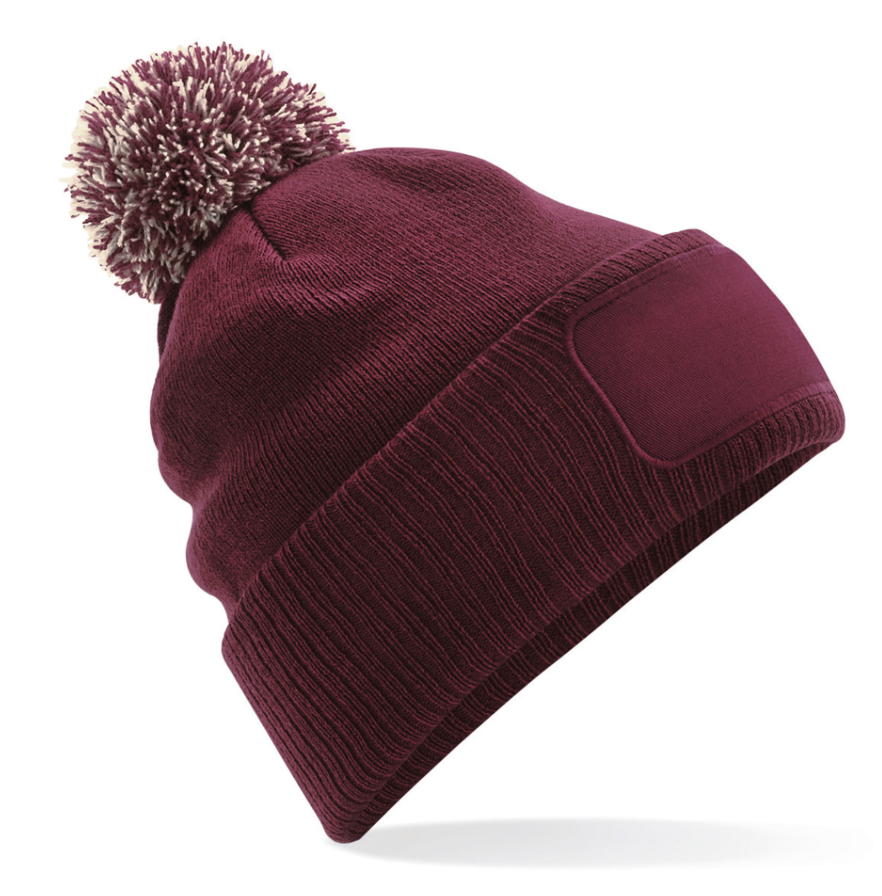 Bonnet B443 avec pompon et patch frontal, chaud et confortable. Idéal pour l’hiver, le merchandising et la personnalisation textile.
